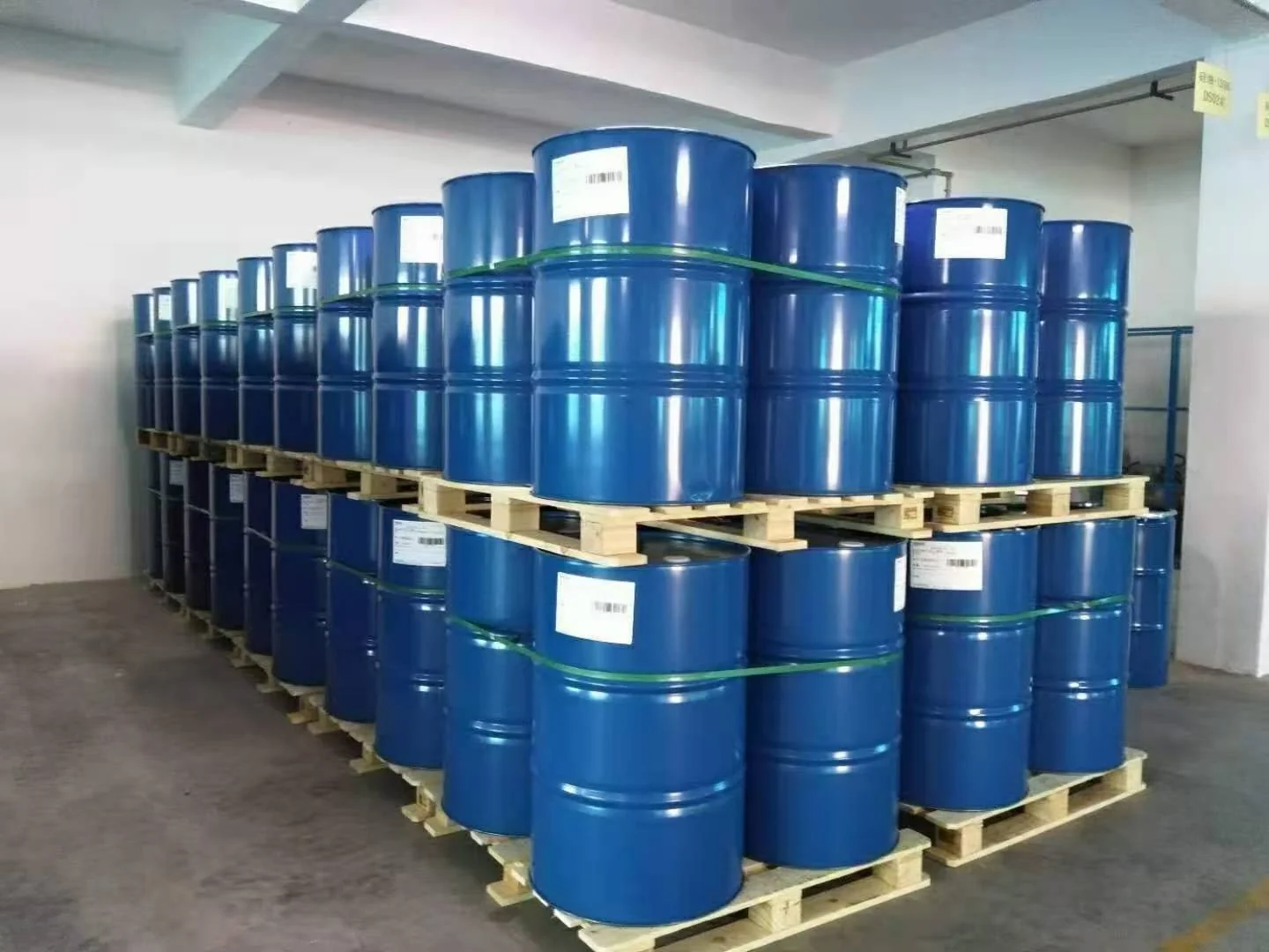Blue metal drums stacked on wooden pallets