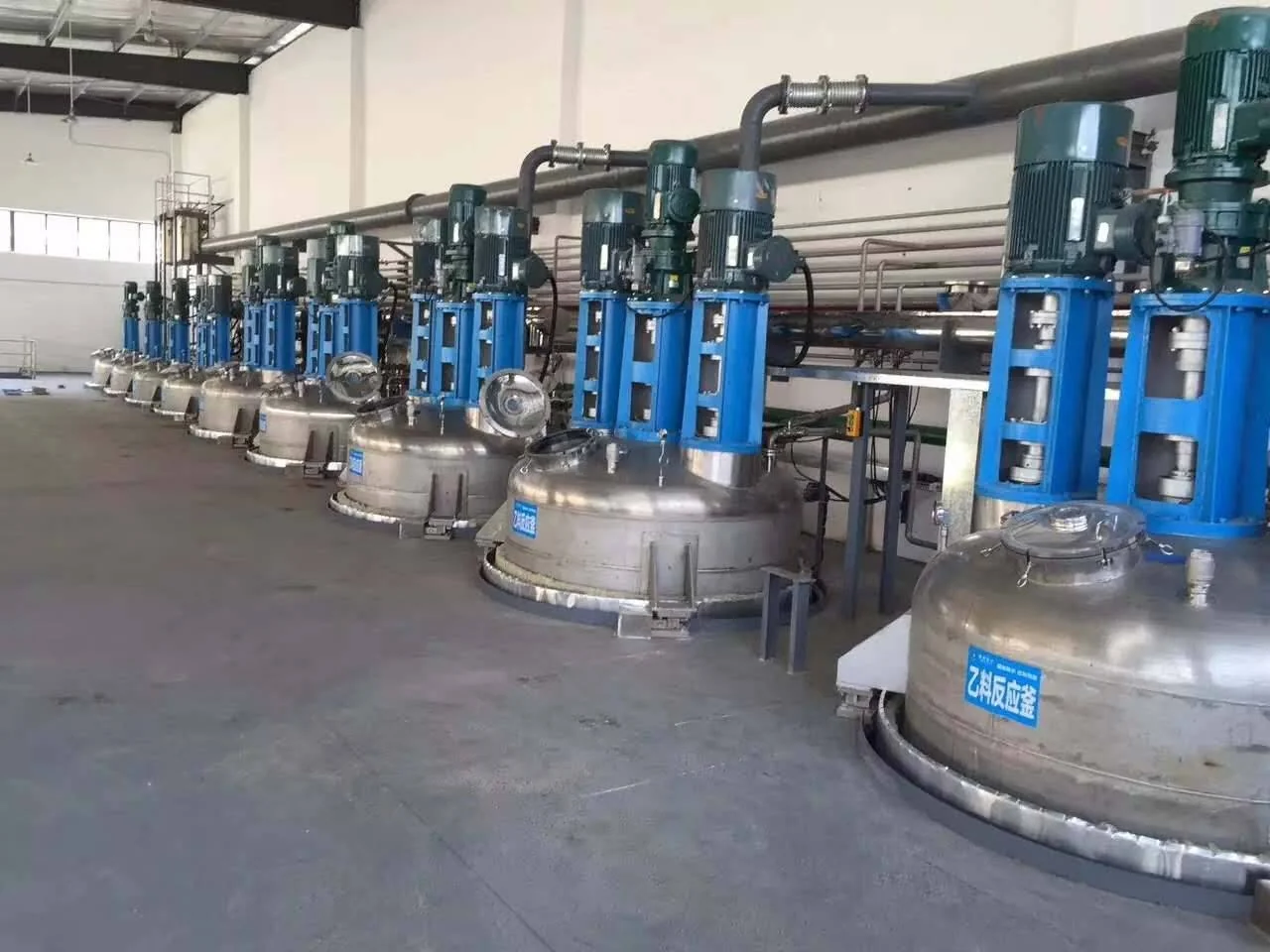 Row of mixing vessels with blue drive assemblies