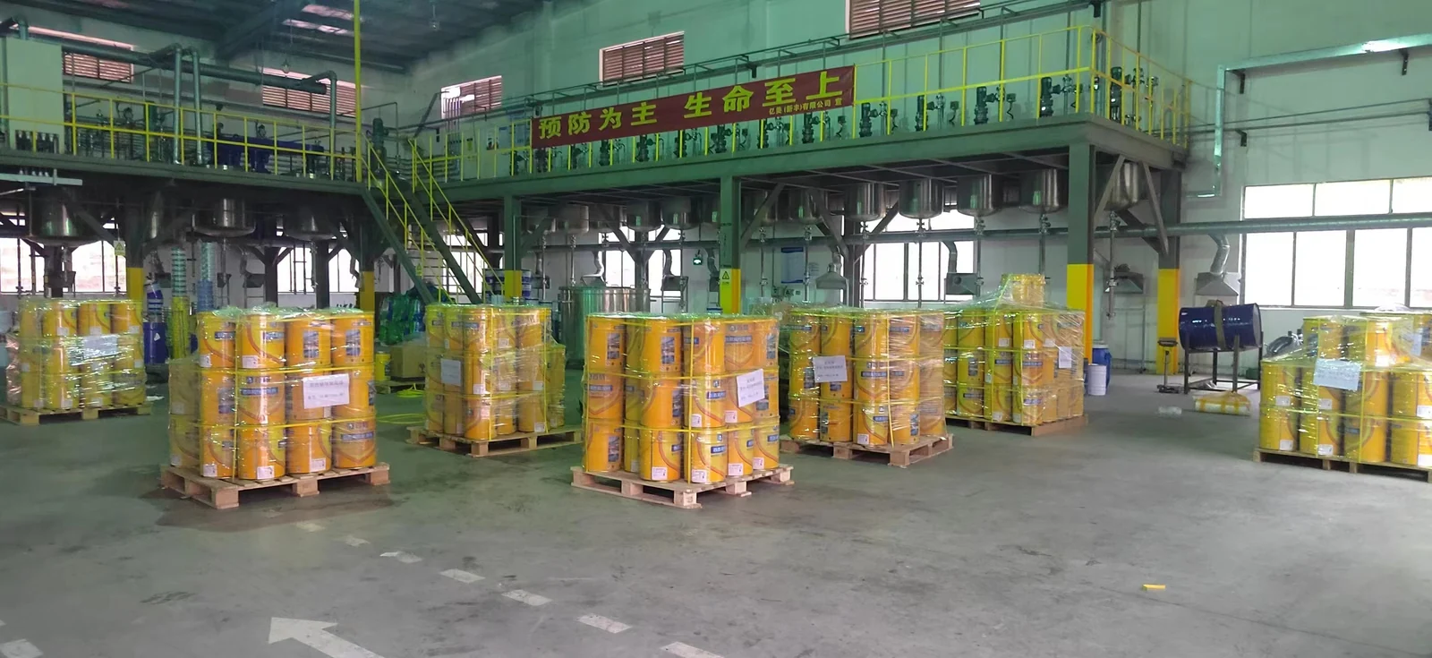 Yellow coating pails wrapped on pallets in a workshop