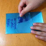 Clear coating being peeled from a blue test panel