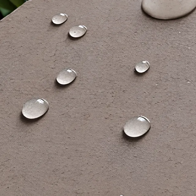 Water beads on a textured stone surface