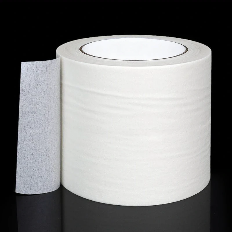 Side view of wide paper masking tape being unrolled