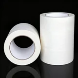 Two upright rolls of extra-wide off-white masking tape