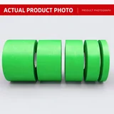 Green low-tack masking tape rolls photographed on a work surface